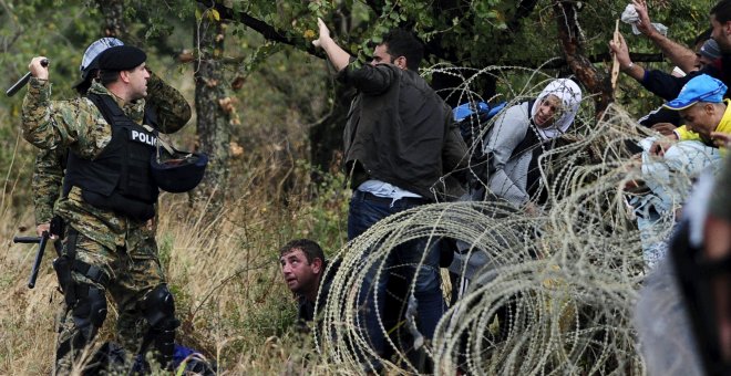 La Policía macedonia trata de detener a los refugiados que cruzan la frontera con Grecia, rumbo a Serbia, cerca de Gevgelija, Macedonia.- REUTERS / Ognen Teofilovski