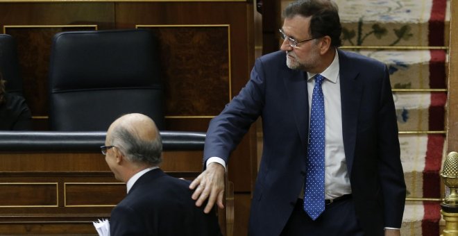 El presidente del Gobierno, Mariano Rajoy, felicita al ministro de Hacienda, Cristóbal Montoro, tras la intervención de éste ante el pleno del Congreso para defender los Presupuestos Generales del Estado para 2016. EFE/Paco Campos