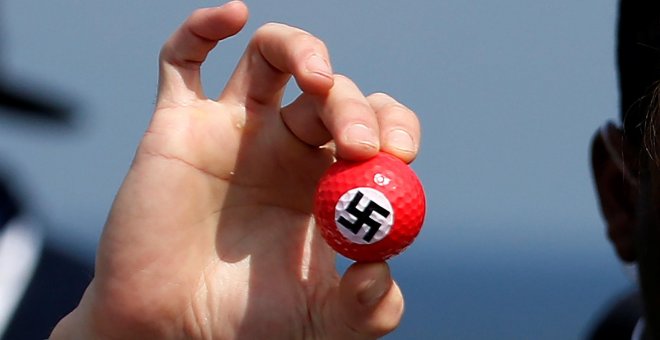 Un manifestante sostiene una pelota de golf con una esvástica dibujada en una rueda de prensa del candidato presidencial republicano Donald Trump en Turnberry Campo de golf en Turnberry , Escocia.- REUTERS / Carlo Allegri