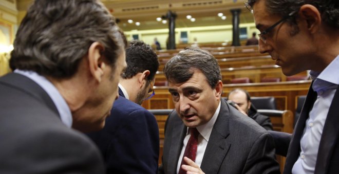 El portavoz parlamentario del PNV, Aitor Esteban, conversa con el portavoz del Grupo Popular, Rafael Hernando, en presencia del diputado socialista Eduardo Madina, durante el pleno del Congreso. EFE/Mariscal