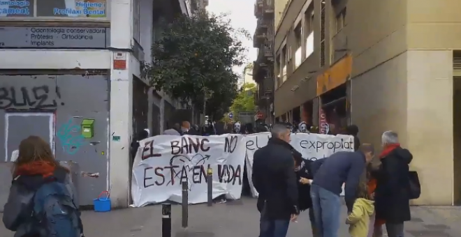 Un momento de la manifestación en la que los presentes portan pancantartas con los mensajes "el banco no está en venta" y "el Banc expropiat se queda en Gràcia". / TWITTER