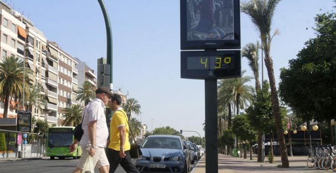 Dos personas pasan junto a un termómetro en Córdoba. - EFE