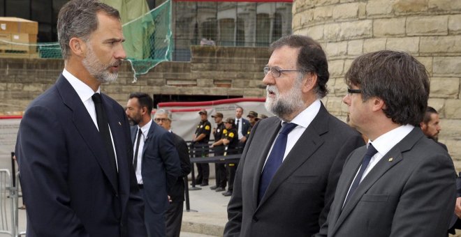 El rey de Felipe VI hablando con el presidente del Gobierno, Mariano Rajoy, y el presidente de la Generalitat de Cataluña, Carles Puigdemont, a su llegada a la basílica de la Sagrada Familia donde se celebró la Misa por la Paz en memoria de las víctimas d