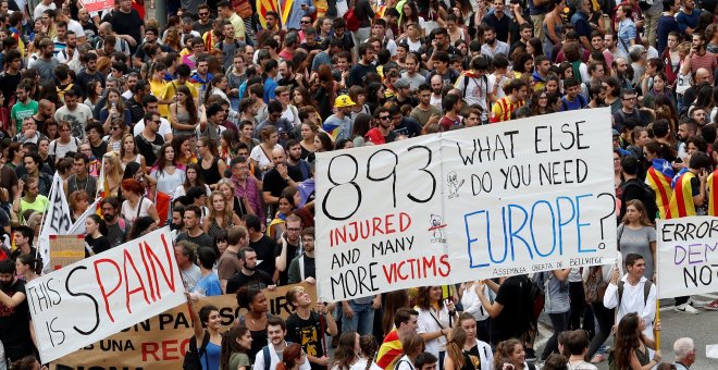 Participantes en la manifestación en protesta por la actuación policial portan carteles pidiendo ayuda a la Unión Europea, en Barcelona, este martes. REUTERS/Yves Herman