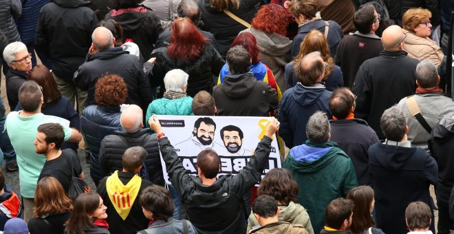 Un manifestante con una pancarta reclamando la puesta en libertad de los presidentes de ANC y Omnium Cutural, Jordi Sanchez y Jordi Cuixart, respectivamente, en la concentración en la Plaza de Sant Jaume durante la jornada de huelga general en Catalunya.