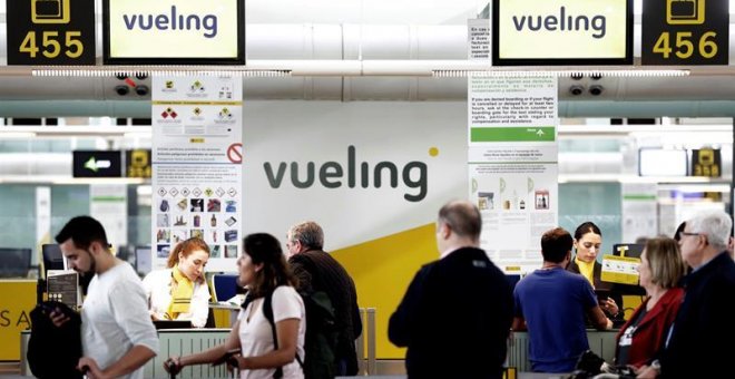 Un grupo de pasajeros ante un mostrador de facturacion de Vueling en el Aeropuerto de Barcelona-El Prat. / EFE