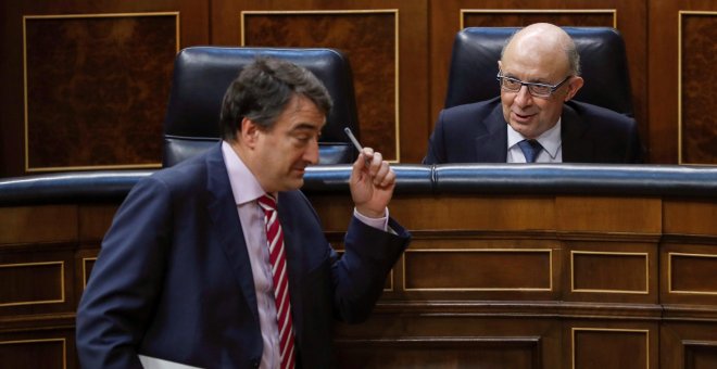 El ministro de Hacienda, Cristóbal Montoro, conversa con el portavoz del PNV, Aitor Esteban, durante el Pleno del Congreso que vota la totalidad del proyecto de Ley de Presupuestos Generales del Estado de 2018. EFE/Emilio Naranjo