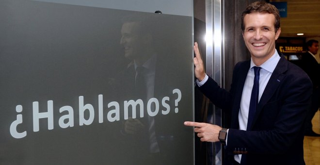 El candidato a la Presidencia del PP Pablo Casado posa junto una publicidad de un establecimiento comercial, en el que se puede leer “¿Hablamos?”. EFE/Nacho Gallego