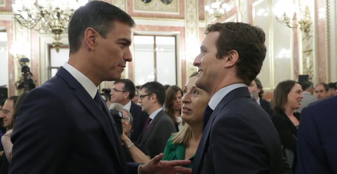 El presidente del Gobierno, Pedro Sánchez, conversa con el líder del PP, Pablo Casado, en presencia de la presidenta del Congreso, Ana Pastor, en el Salón de los Pasos Perdidos poco antes de la presentación de los actos conmemorativos del cuarenta anivers