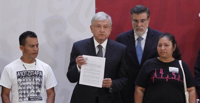El presidente de México Andrés Manuel López Obrador  sostiene el decreto presidencial para la instalación de una Comisión de la Verdad junto a los padres de dos de las  víctimas de los 43 estudiantes de Ayotzinapa. (Sáshenka Gutiérrez | EFE)