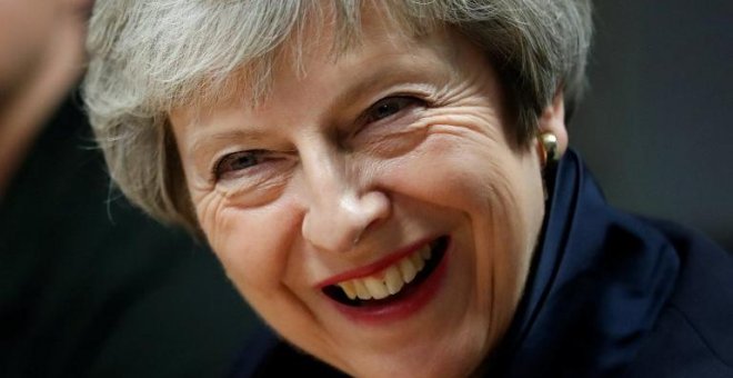 La primera ministra británica, Theresa May, reacciona durante su visita al Scottish Leather Group Limited en Bridge of Weir en Escocia el 28 de noviembre de 2018 | AFP