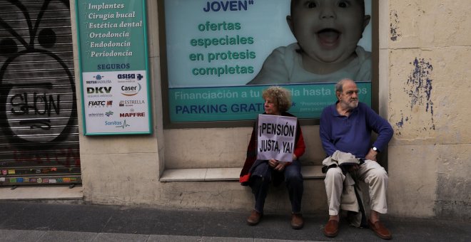 Manifestantes, con un cartel que demanda "Pensión justa, ahora", sentados junto a una clínica en Madrid. REUTERS / Susana Vera