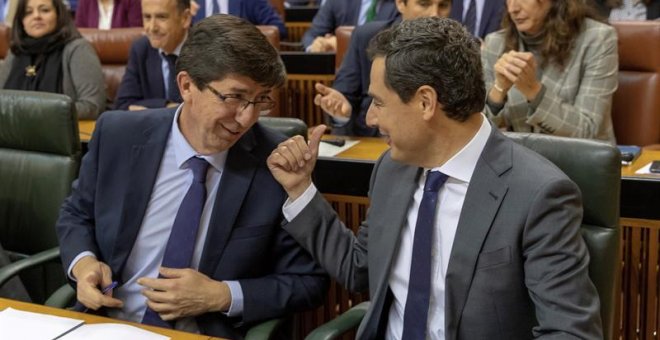 06/02/2019.- El presidente andaluz, Juanma Moreno, y el vicepresidente, Juan Marín (i), conversan en sus escaños durante el pleno del Parlamento de Andalucía esta tarde en Sevilla, que ha elegido, en la primera sesión plenaria de la XI Legislatura, a los