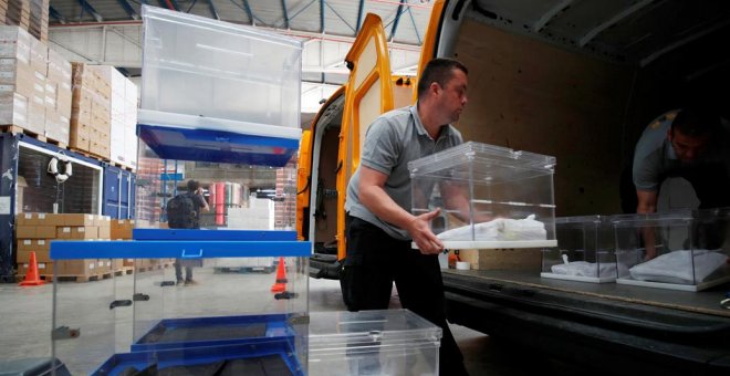Los operarios trasladan las urnas que se van a emplear en la jornada electoral del 26-M. REUTERS/Albert Gea