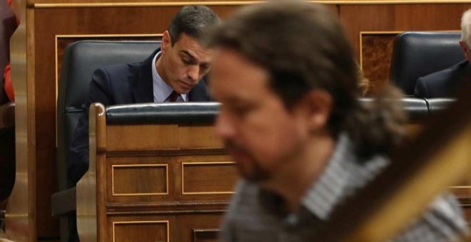 Pablo Iglesias, de camino a la tribuna del Congreso mientras Pedro Sánchez toma unas notas. (J.J. GUILLÉN | EFE)