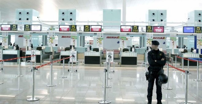 Un mosso de esquadra ante los mostradores de facturación de Iberia, en el aeropuerto de Barcelona-El Prat. EFE/Andreu Dalmau/Archivo