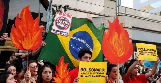 Manifestantes de organizaciones medioambientales participan en una manifestación frente a la embajada de Brasil para exigir más protección de la Amazonía | Reuters