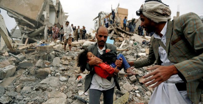 Un hombre lleva en brazos a una niña herida en un bombardeo de la coalición saudí contra Yemen en agosto de 2017. Khaled Abdullah / REUTERS