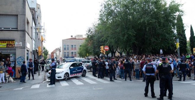 Mossos d'Esquadra controlan a la multitud que se ha congregado ante el domicilio en el que agentes de la Guardia Civil llevan a cabo un registro en Sabadell (Barcelona). /EFE