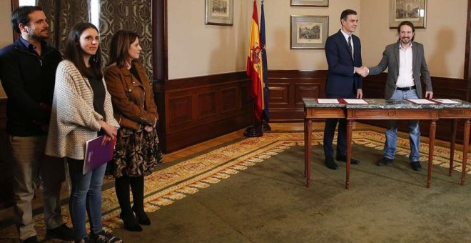 GRAF7665 MADRID, 12/112019.- El presidente del Gobierno español en funciones, el socialista Pedro Sánchez (c), y el líder de Unidas Podemos, Pablo Iglesias,d se estrechan las manos tras llegar hoy a un acuerdo para la formación de un Ejecutivo en España t