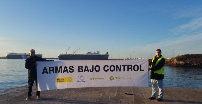 Integrantes de Armas Bajo Control en el puerto de Sagunto, con el barco Bahri Abha de fondo. AMNISTÍA INTERNACIONAL