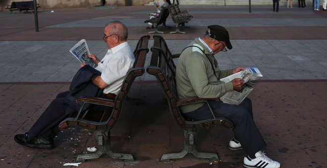 Unos pensionistas leen el periódico sentadados en un banco, en Madrid. REUTERS / Susana Vera