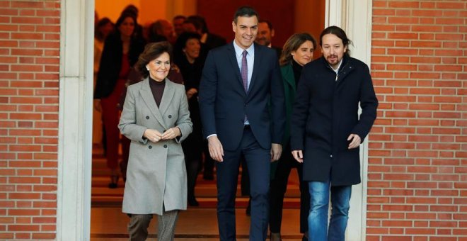 El primer ministro, Pedro Sánchez (C), camina junto a la vicepresidenta primera y ministra de Presidencia y Realciones con las Cortes, Carmen Calvo (i), y el vicepresidente de Derechos Sociales y Agenda 2030, Pablo Iglesias (d), momentos antes de posar pa