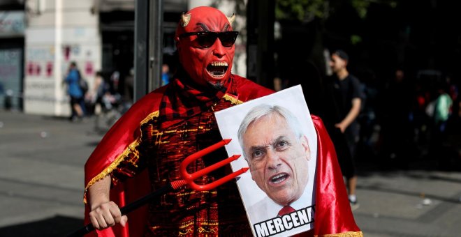 Un manifestante con una pancarta de Sebastián Piñera durante una protesta en Santiago de Chile. - REUTERS