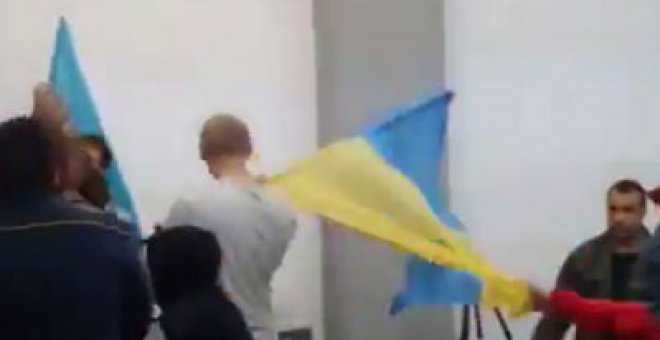 Una persona arrebata la bandera a un nacionalista ucraniano.