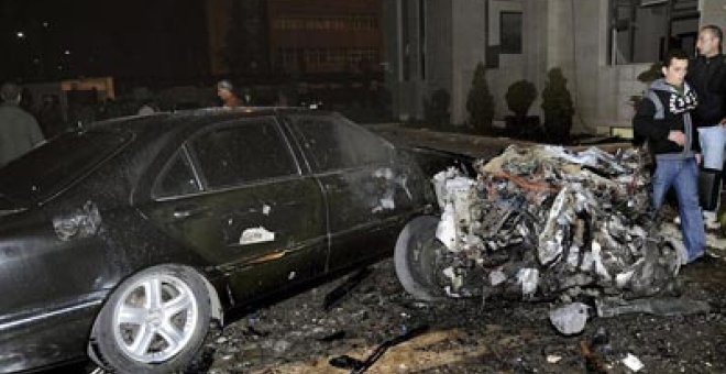 Fotografía cedida facilitada por la agencia siria de noticias SANA que muestra a unos policías sirios inspeccionando el lugar donde se ha registrado un atentado con coche bomba ante la sede del Ministerio del Interior sirio. -