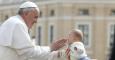 El papa Francisco se dispone a abrazar a un bebé cerca del Vaticano. -REUTERS