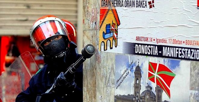 Un agente se aposta con una escopeta de pelotas de goma en una esquina de la de parte vieja de San Sebastián.