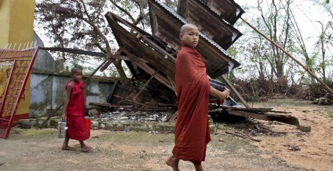 Dos jóvenes monjes birmanos caminan cerca de un templo destrozado en las afueras de Yangón, Birmania.