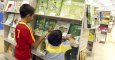 Imagen de dos niños observando los libros de texto en unos grandes almacenes madrileños.