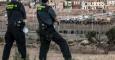 Dos agentes de la Guardia Civil vigilan la frontera de Melilla ante el intento de un grupo de personas de saltarla. AFP