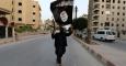 Militante del Estado Islámico agita la bandera negra de su organización. Foto: Reuters