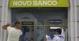 Unos trabajadores instalan el nuevo logo del portugués Novo Banco en una de sus sucursales de Lisboa. REUTERS