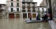Miembros de Proteccion Civil ayudan a varias personas en el Casco Viejo de Tudela, coincidiendo con la máxima crecida del Rio Ebro, donde se han inundado las calles de la ciudad. /Jesús Diges (EFE)