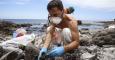 Un voluntario realiza labores de limpieza en una de las playas afectadas de Gran Canaria. EFE