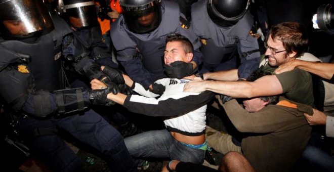 La Polícia trata de detener a uno de los jóvenes | Foto: EFE