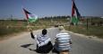 Protestantes palestinos sostienen banderas palestinas mientras militares israelíes toman posiciones durante una protesta contra los asentamientos ilegales en Cisjordania, al lado de Ramala./ REUTERS/Mohamad Torokman