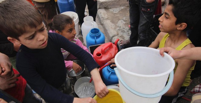 Unos niños esperan que para recoger agua potable en la ciudad siria de Alepo. REUTERS/Giath Taha
