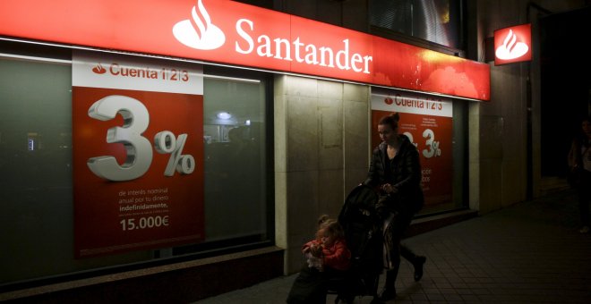 Una mujer con el carrito de su bebé pasa por delante de una oficina del Banco Santander. REUTERS/Andrea Comas