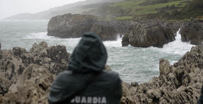 Un agente de la Guardia Civil supervisa la zona donde un pescador cántabro ha desaparecido. EFE/Pedro Puente Hoyos