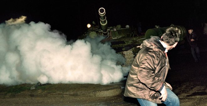Un manifestante lituano corre frente a un tanque del ejército soviético durante el asalto a la estación de radio y televisión lituana el 13 de enero de 1991. AFP