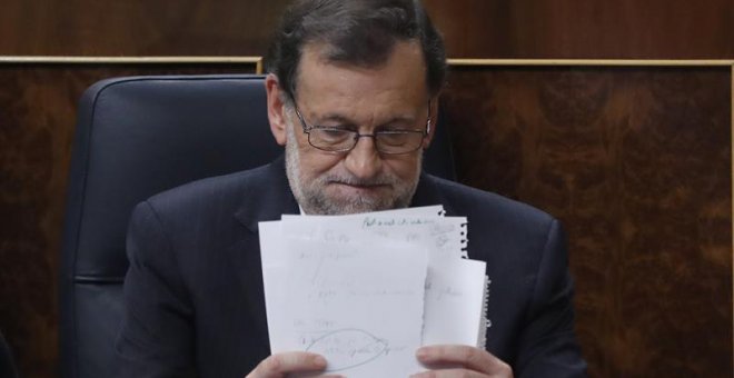 El presidente del Gobierno en funciones y candidato del PP, Mariano Rajoy, coloca unos papeles durante la sesión de la tarde de la segunda jornada del debate de investidura, hoy en el Congreso de los Diputados. EFE/Chema Moya