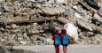 Dos niñas con mochilas donadas por UNICEF pasan junto a un edificio derruido en Alepo de camino a la escuela. Fotografía de marzo de 2015. - ZEIN AL-RIFAI (AFP)