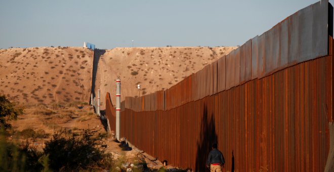 Un hombre pasa por una sección del muro que separa EEUU de México, cerca de Ciudad Juarez. REUTERS/Jose Luis Gonzalez