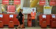 Una mujer pasa junto a los terminales de facturación de Iberia en la Terminal T4 del aeropuerto de Barajas. AFP/Pedro Armestre