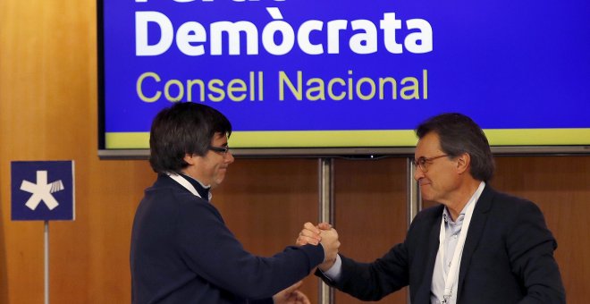 El presidente de la Generalitat, Carles Puigdemont, saluda al expresidente Artur Mas, tras su intervención ante el consell nacional del PDeCat. EFE/Alberto Estévez